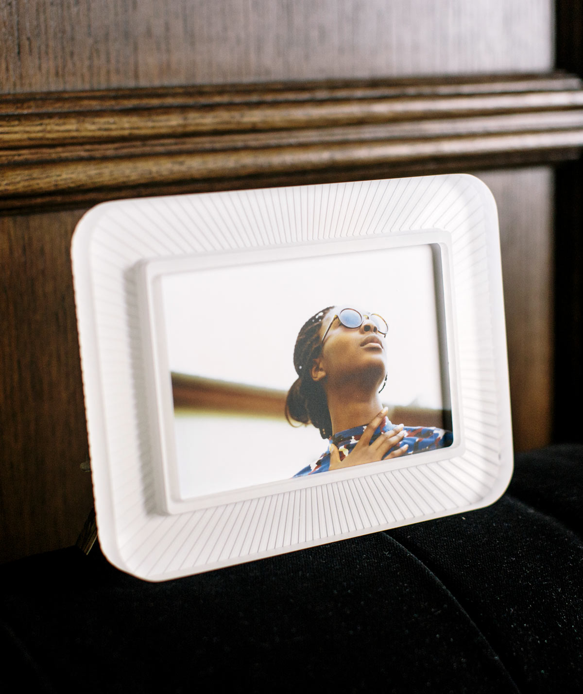 Rays Snow White Frame with textured ridges, in a decorated space in front of a wood wall